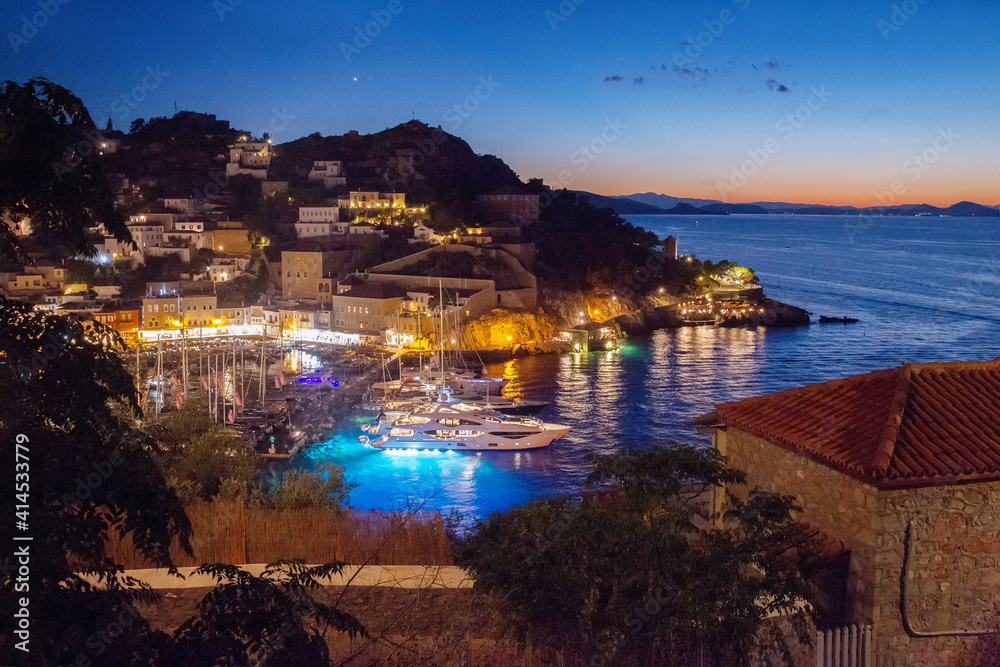 amazing scne with harbow , motor yachts and sailng boats and electric lights from houses in Hydra town on greel island