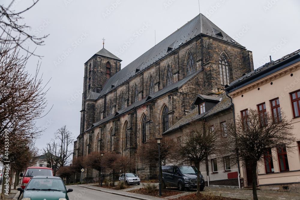 Gothic stone church of the Nativity of the Virgin Mary in winter day, cityscape of medieval town with historical buildings, Bohemian Paradise, Turnov, Czech Republic