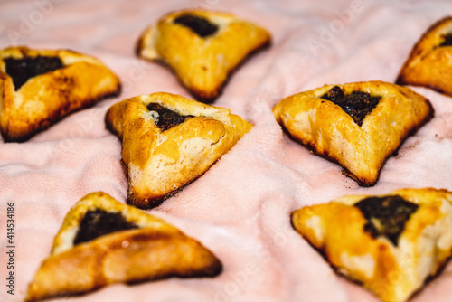 Purim holiday celebration. Hamantaschen cookies on pink background. Top view photo