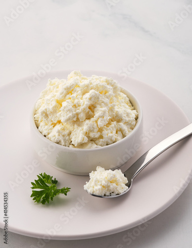 Fresh cottage cheese in a white bowl.
