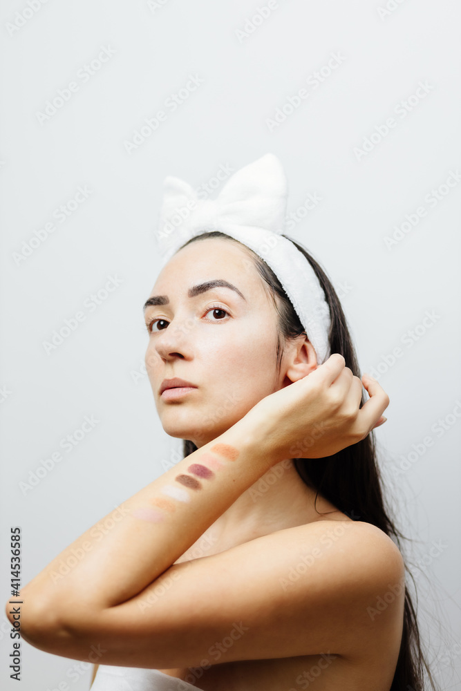 woman choosing eyeshadow palette. makeup artist testing eyeshadow colors on her hand. cosmetic testing.