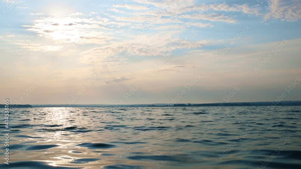 Beautiful dramatic scenic bright vibrant blue to red warm sunrise morning time landscape panorama with cloudscape reflection on ripple water surface of lake or river. Horizon coast line on background Beautiful dramatic scenic bright vibrant blue to red warm sunrise morning time landscape panorama with cloudscape reflection on ripple water surface of lake or river. Horizon coast line on background