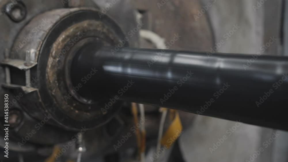 Applying a heat shrink layer to a thick power shielded cable on a production line in a factory. Applying a heat shrink layer to a thick power shielded cable on a production line in a factory.
