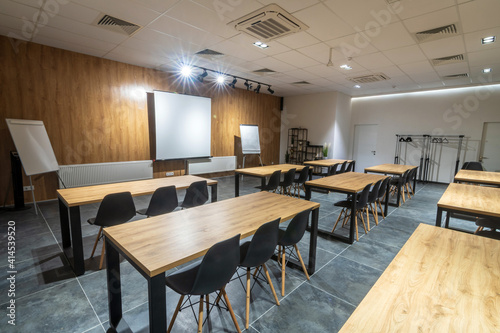  Interior of an empty classroom conference hall with black chairs   flipcharts and white screen.