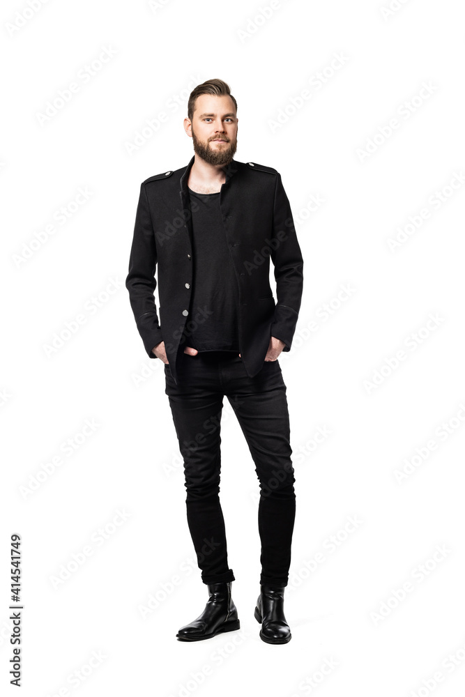 Handsome and tall Scandinavian male wearing an all black outfit standing casually with both hands in his pockets standing against a white background. Handsome and tall Scandinavian male wearing an all black outfit standing casually with both hands in his pockets standing against a white background.