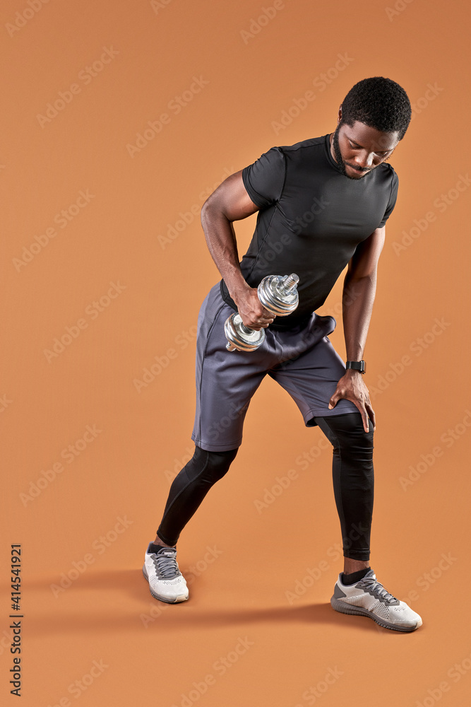 afro man doing weight exercises isolated on brown background, sport, workout, healthy lifestyle concept