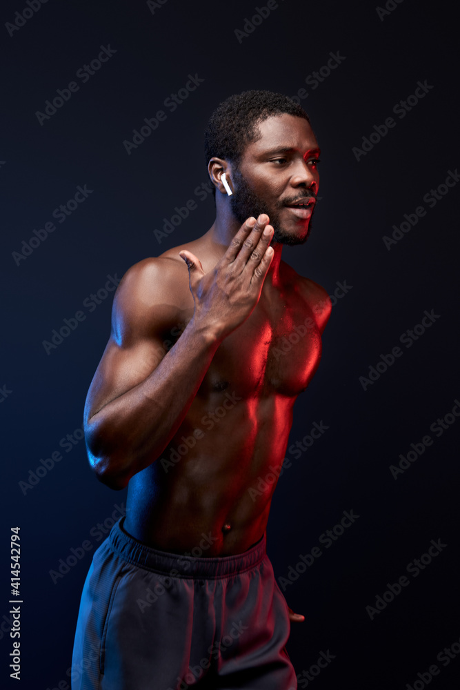 confident black sportsman running, isolated on black background. muscular strong male engaged in sport, have athletic body