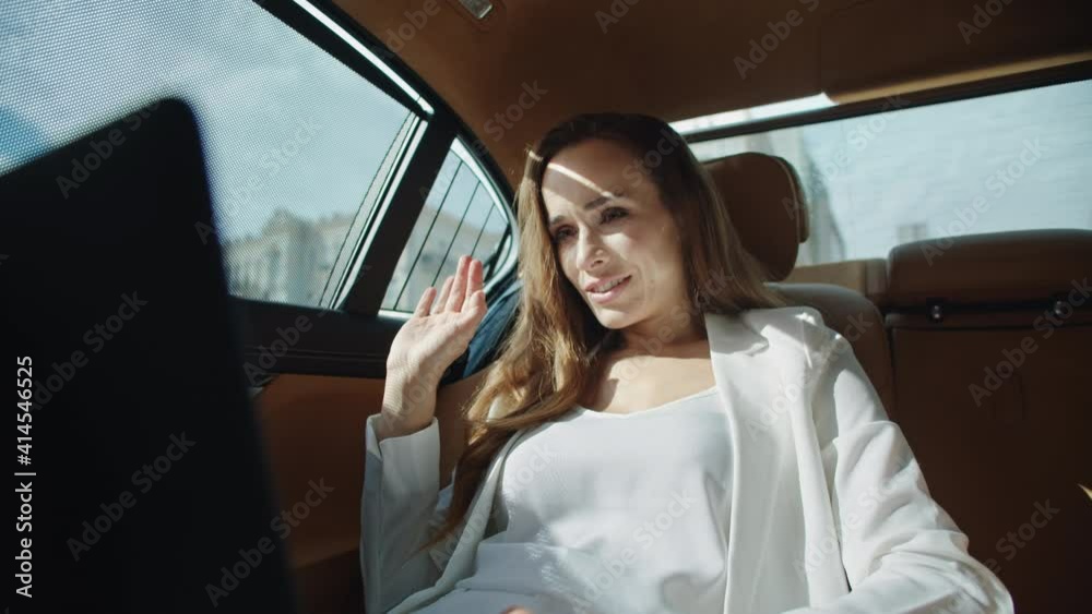 Portrait of friendly business woman talking on video call in business car. Portrait of friendly business woman talking on video call in business car.
