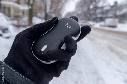 Canvas Print Closeup of an electric pocket hand warm during snow fall