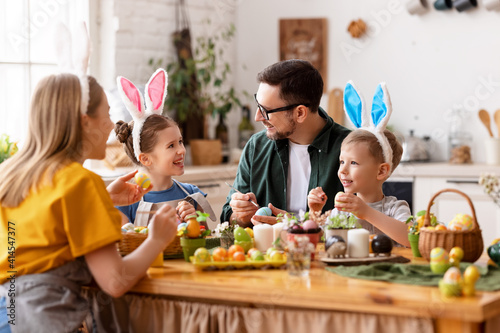 Photography Happy easter! family mother, father and children paint eggs for holiday