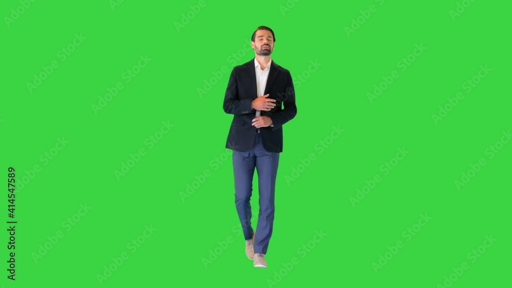 Young handsome business man walking and talking to himself on a Green Screen, Chroma Key.