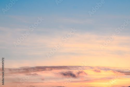 Sunset theme for sky replacement background with pink, orange, pastel clouds, blue sky and sun shining on the horizon. Great for tranquil, calm, serene country or rural themed art. © Scalia Media