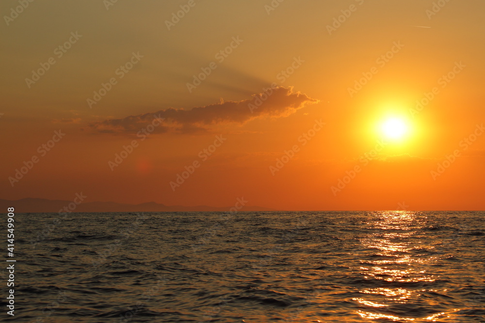 Orange bright sunset under the ocean. Sun reflection on water scenic, yellow dusk, peaceful nature landscape
