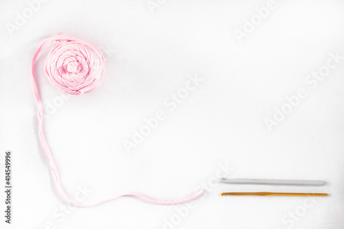 ribbon yarn ball closeup, pink yarn for knitting and crochet hook, handmade concept banner