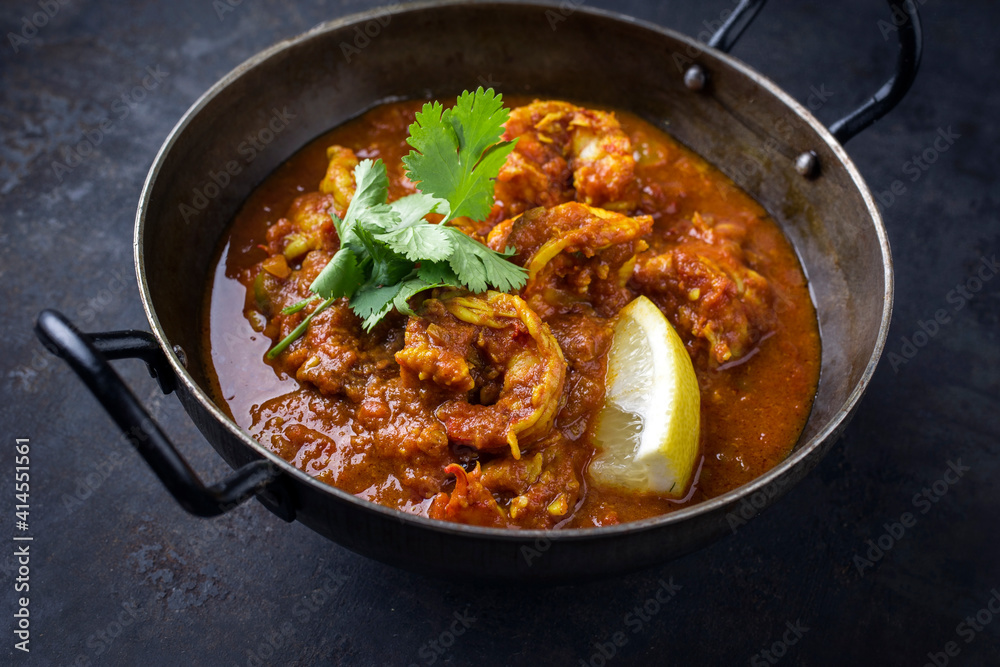 Traditional Indian jhinga masala with king browns served as close-up in a design bowl Traditional Indian jhinga masala with king browns served as close-up in a design bowl