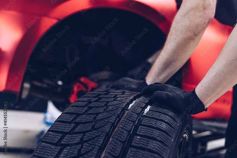 Changing car tire and wheel in the professional car mechanical service