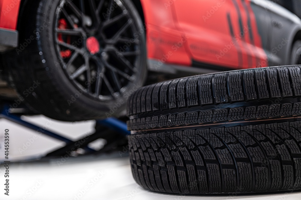 Changing car tire and wheel in the professional car mechanical service