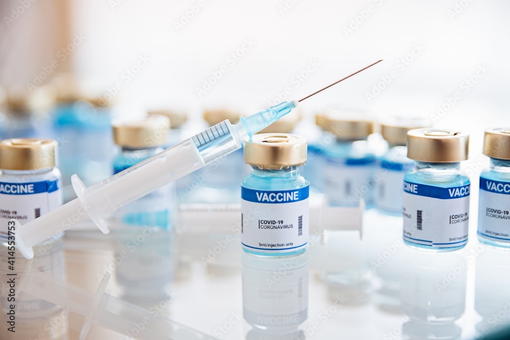 Ampoules of Covid-19 vaccine in a research lab. Syringe with a needle. Pandemic time. Ampoules of Covid-19 vaccine in a research lab. Syringe with a needle. Pandemic time.