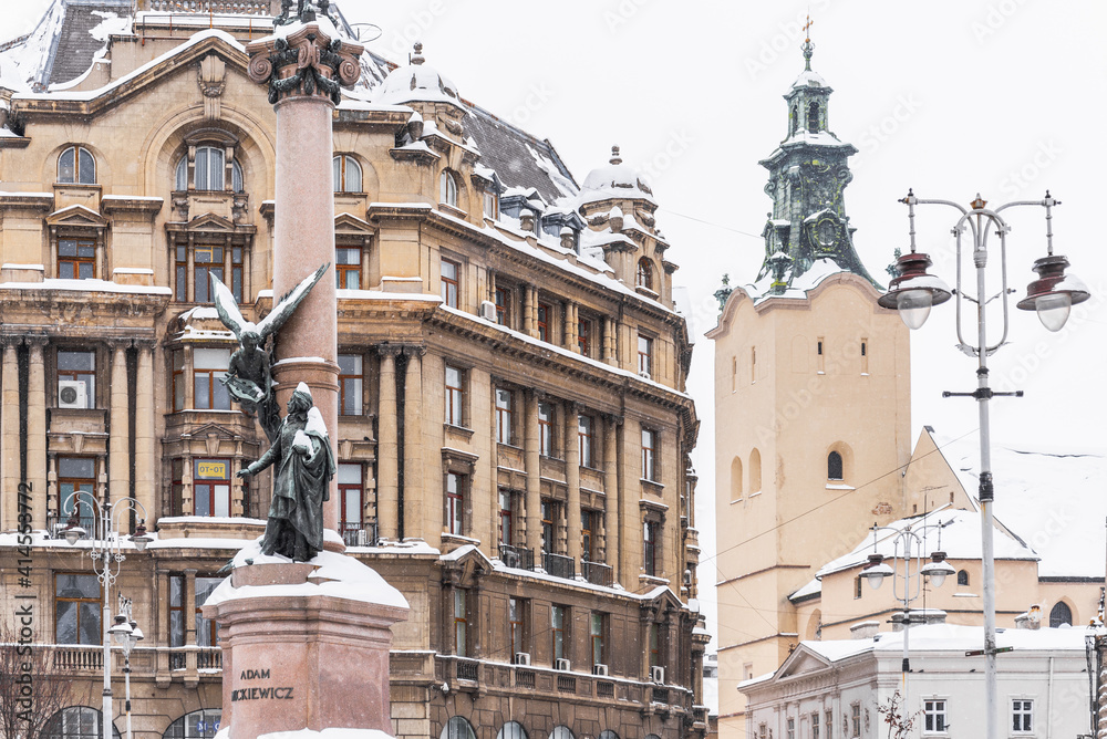 LVIV, UKRAINE - FEBRUARY 12, 2021:  Monument To Adam Mickiewicz and the Bell tower of Latin Cathedral