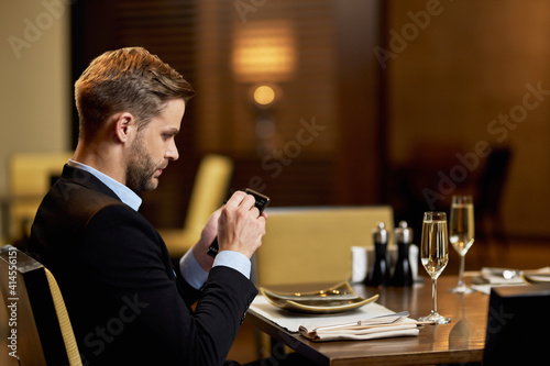 Focused restaurant visitor checking his personal device