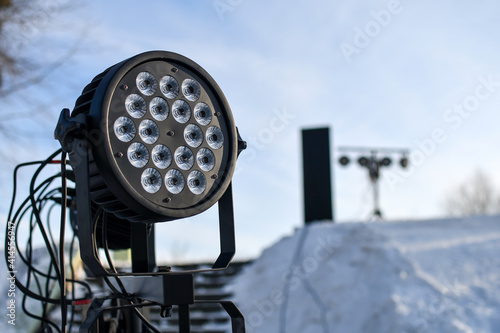 Close up of light and music projector equipment installed outdoors in winter. Selective focus.