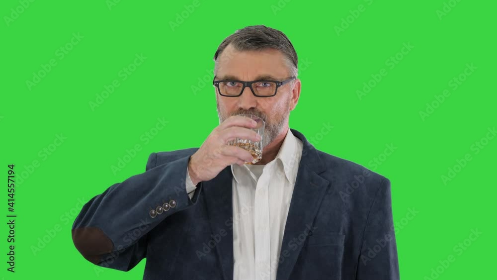 Old man in glasses drinking whiskey Cheers on a Green Screen, Chroma Key. Old man in glasses drinking whiskey Cheers on a Green Screen, Chroma Key.