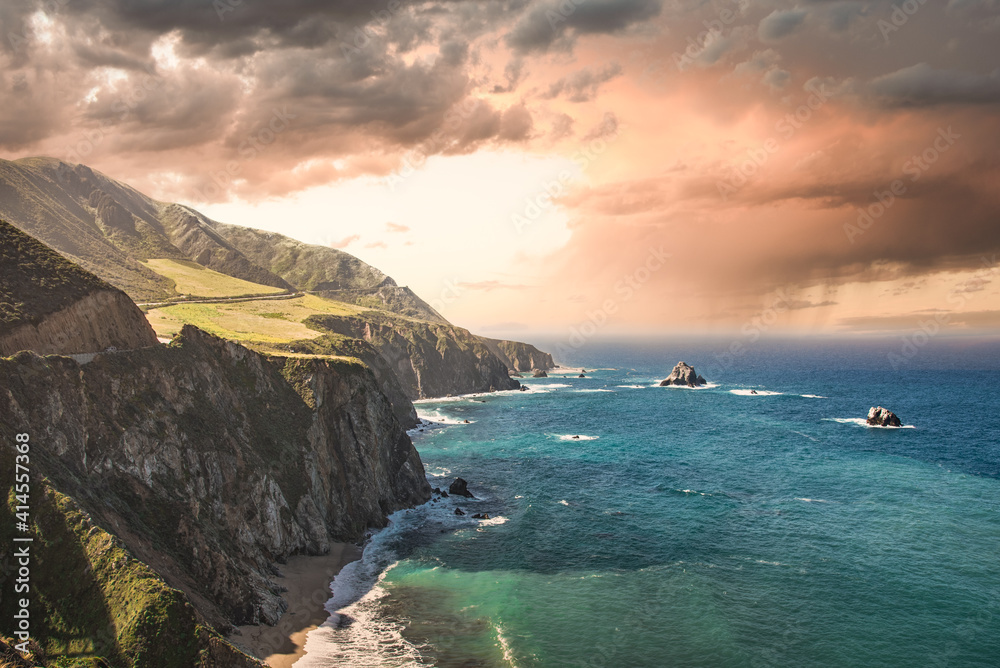 Big Sur during the spring time in California, United States with stunning orange, pink stormy sky and cliff faces dropping down directly into the Pacific Ocean. Big Sur during the spring time in California, United States with stunning orange, pink stormy sky and cliff faces dropping down directly into the Pacific Ocean.
