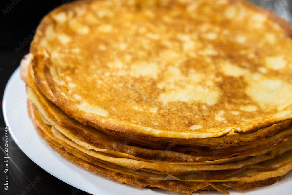 a stack of pancakes on a white plate