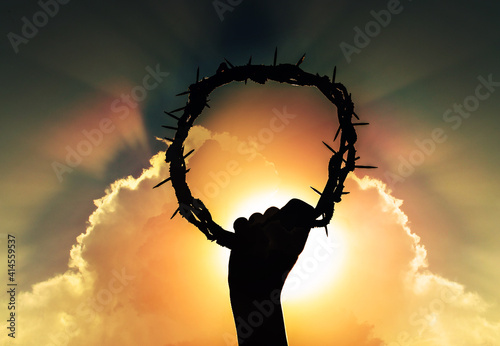 Photography hand of Jesus christ with sky and rising sun, holding crown of thorns, critsão s