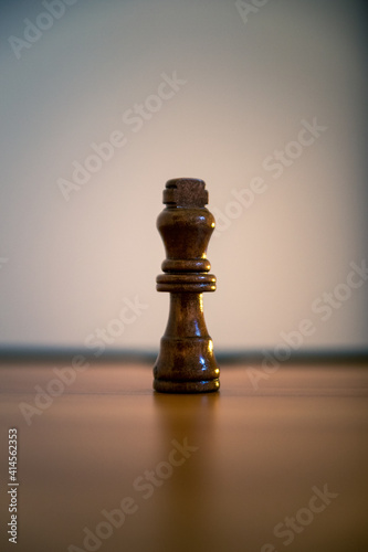 Chess black king piece on a wooden surface