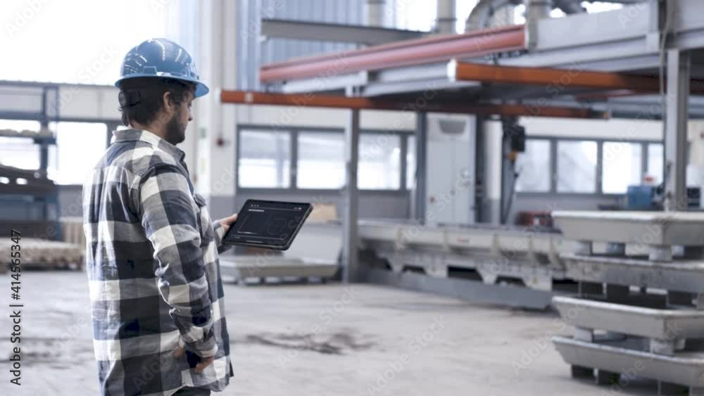Mann bedienet Tablet in smarter Fabrik Mann bedienet Tablet in smarter Fabrik