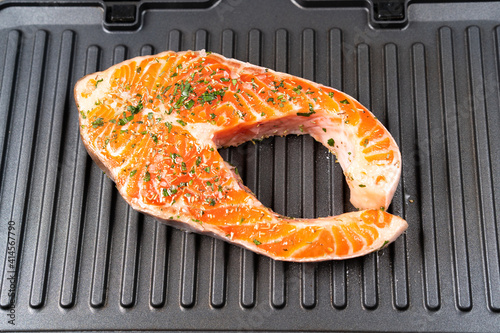 fresh raw salmon steak on electric grill photo