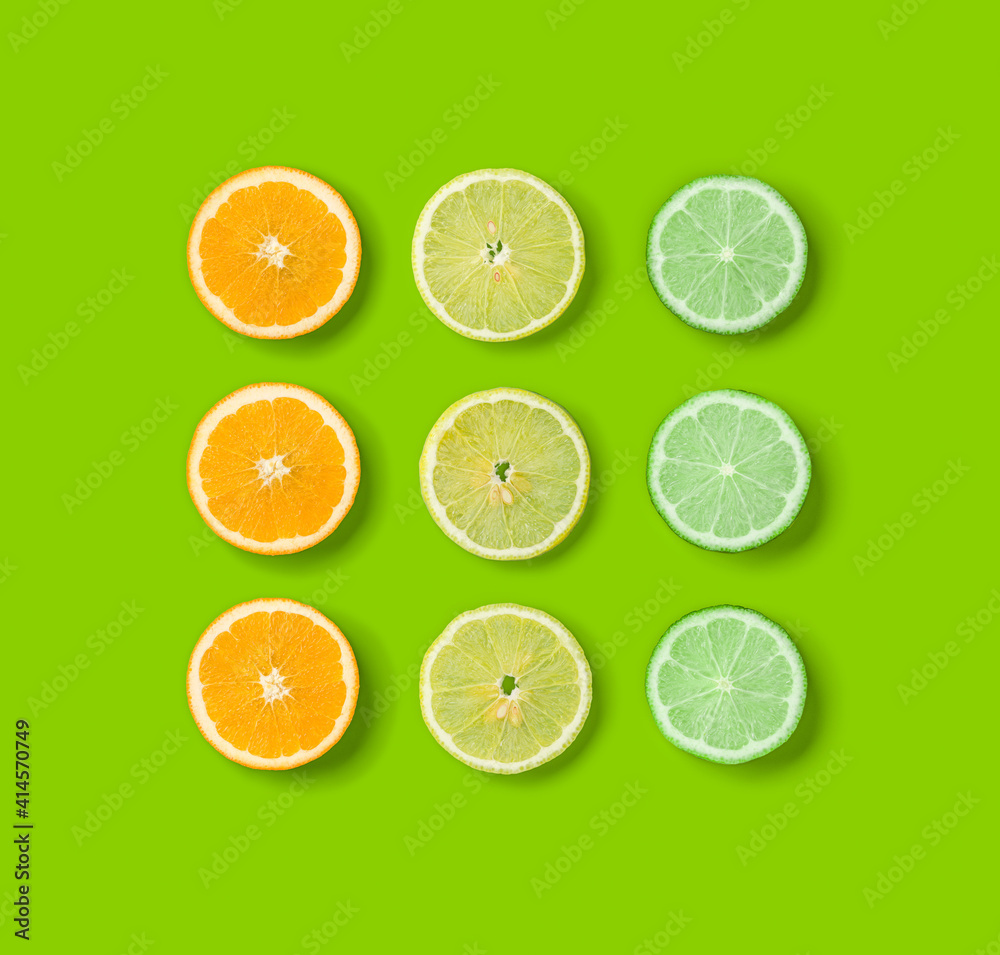 Citrus Fruits pattern on green background. Orange, Lime, Lemon slices background. Flat lay, top view. Citrus Fruits pattern on green background. Orange, Lime, Lemon slices background. Flat lay, top view.
