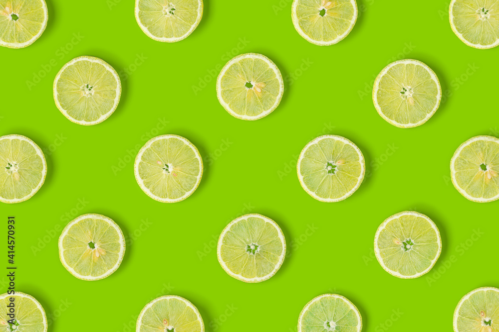 Fruit pattern of lemon slices on green background. Flat lay, top view.