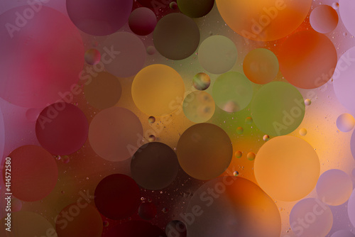 bright colorful oily drops in water with colorful background, close-up 