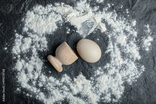 Принти на полотні Egg cup and raw egg on floury background