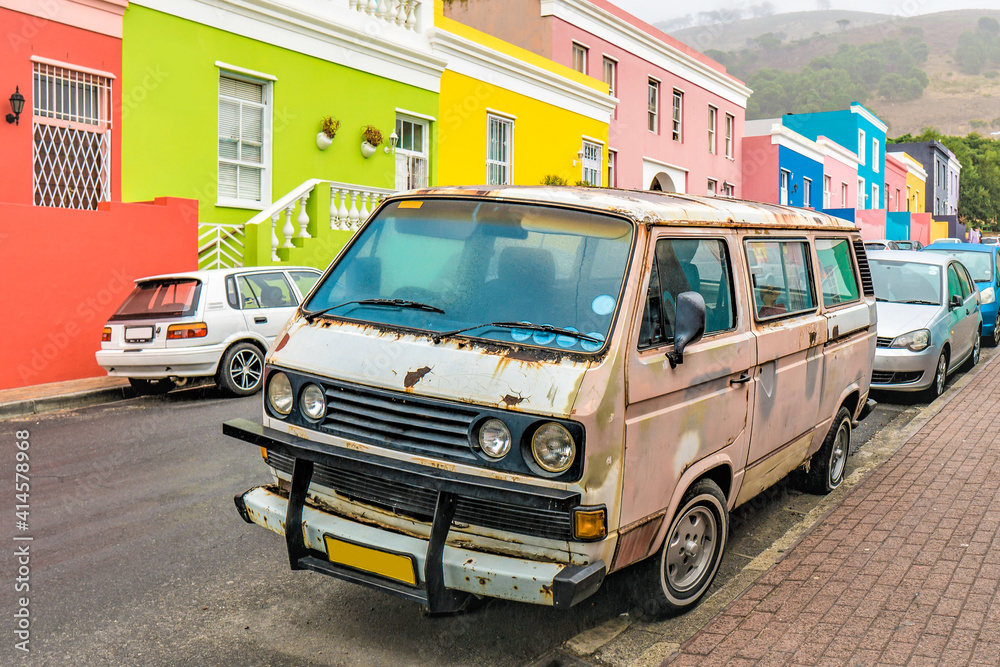 Obraz premium rusty bus infront of colorfull houses in captown south africa