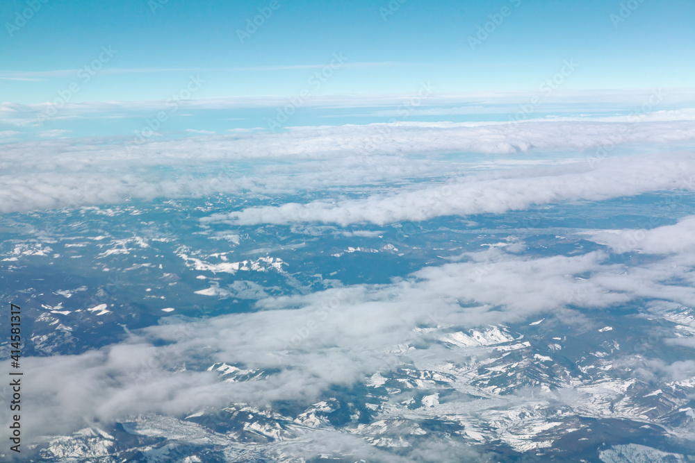 Above clouds and snowy mountains . Aerial winter alpine scenery 