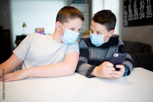 two boys in masks taking selfies