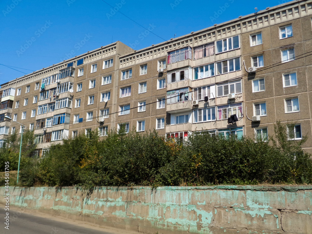 Old Apartment building. Soviet architecture. Ust-Kamenogorsk (Kazakhstan). Soviet architectural style. Typical socialist apartment building. Apartment block. Blue sky. Plattenbau Old Apartment building. Soviet architecture. Ust-Kamenogorsk (Kazakhstan). Soviet architectural style. Typical socialist apartment building. Apartment block. Blue sky. Plattenbau