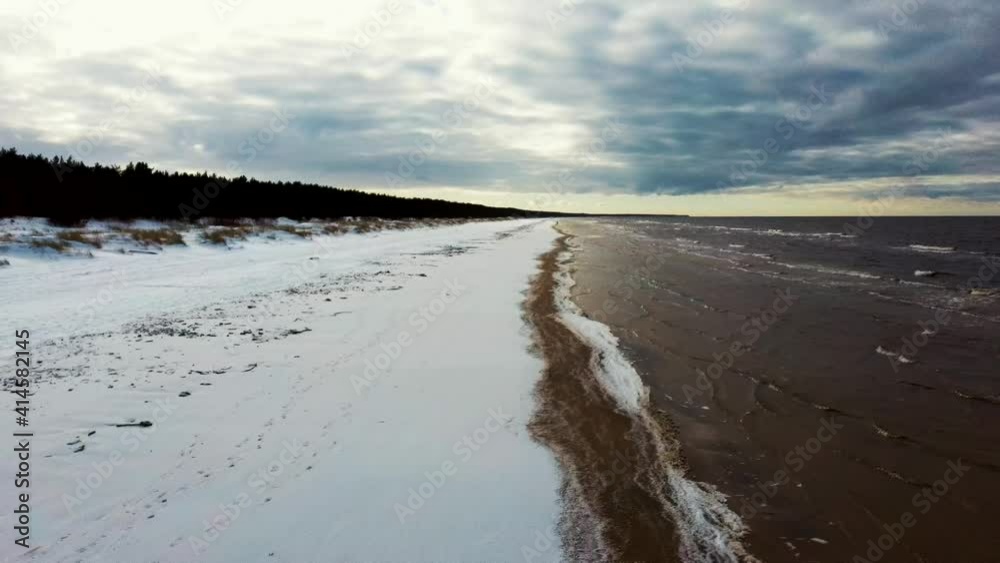 Aerial View at the Baltic Sea, Winter Season Landscape by the Sea in Sunny Day. Snowy Beach at Winter. 4k Dron Shot Aerial View at the Baltic Sea, Winter Season Landscape by the Sea in Sunny Day. Snowy Beach at Winter. 4k Dron Shot