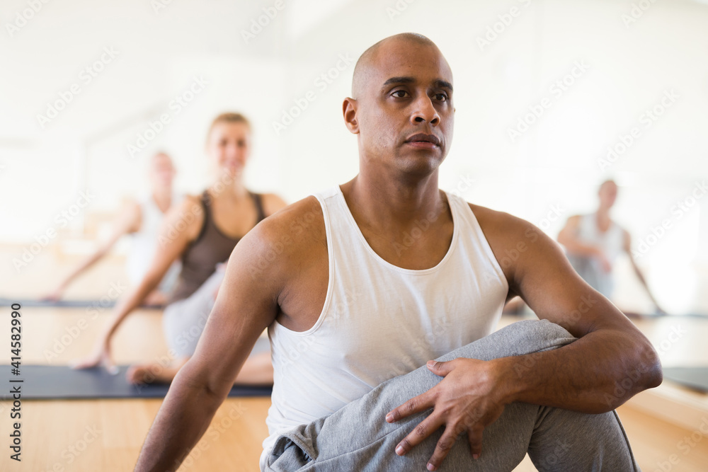 Obraz premium Positive man practicing yoga lesson at group class, maintaining healthy lifestyle