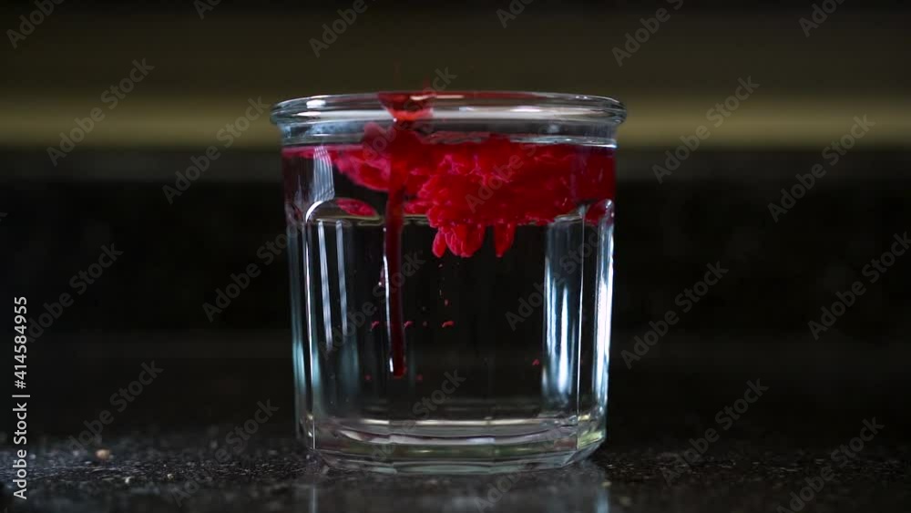 Hot Melted Red Wax Poured into Cold Glass of Clear Water (120 FPS) Hot Melted Red Wax Poured into Cold Glass of Clear Water (120 FPS)