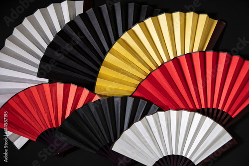 Color ful Chinese Fan stack on black background