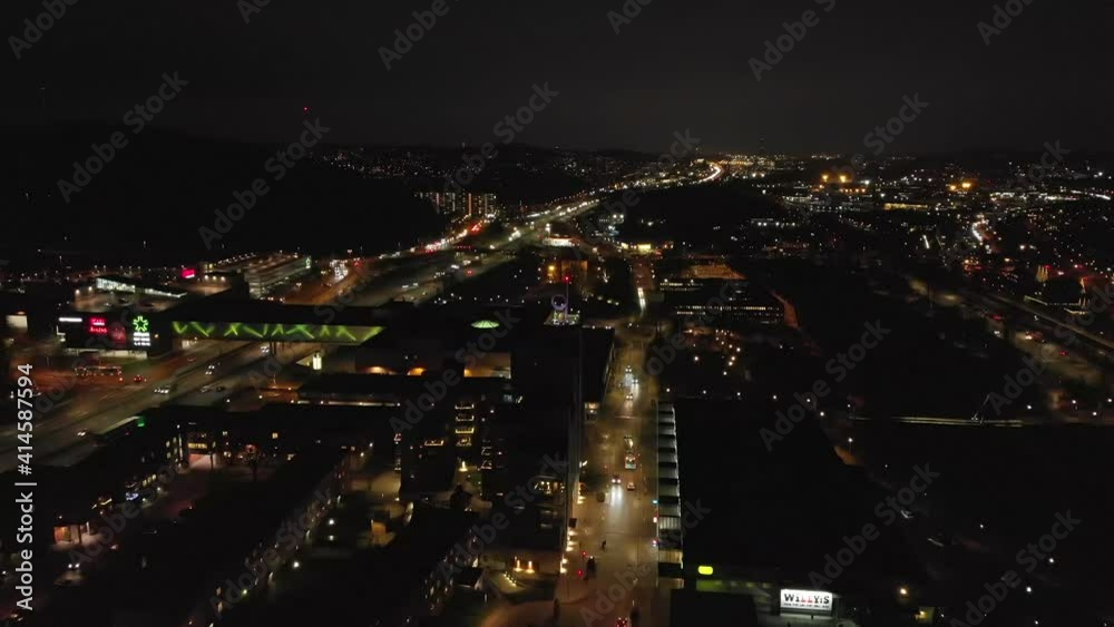 Stunning night-time aerial of downtown Partille and European route E6 highway with illuminated skyline, buildings and street lights in Gothenburg City, Sweden. Stunning night-time aerial of downtown Partille and European route E6 highway with illuminated skyline, buildings and street lights in Gothenburg City, Sweden.