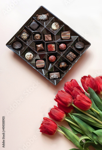 Box of chocolates and red tulips.  Flat lay, top view.