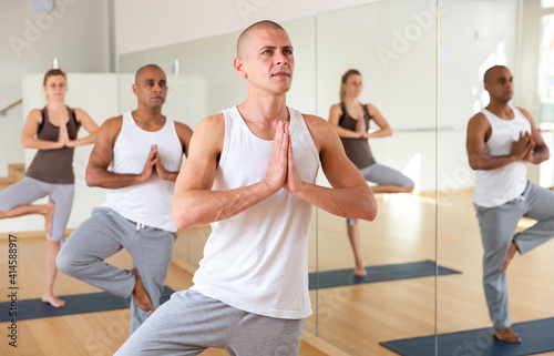 Portrait of man practicing yoga lesson at group class  maintaining healthy lifestyle