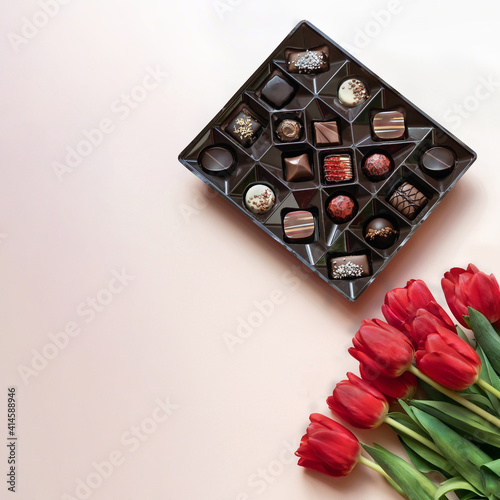 Box of chocolates and red tulips.  Flat lay, top view.