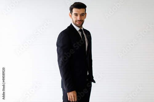 Image is a portrait. Happy and smiling businessman standing smart with black suit In the studio with a white background.