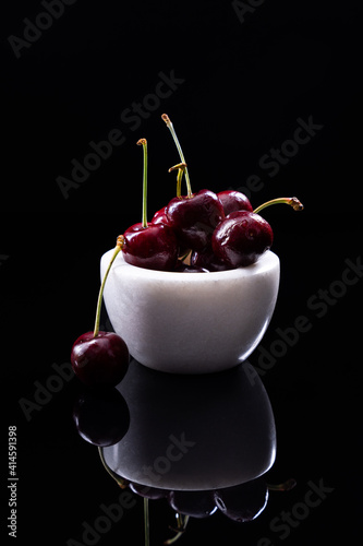 Bowl of cherries on a black background